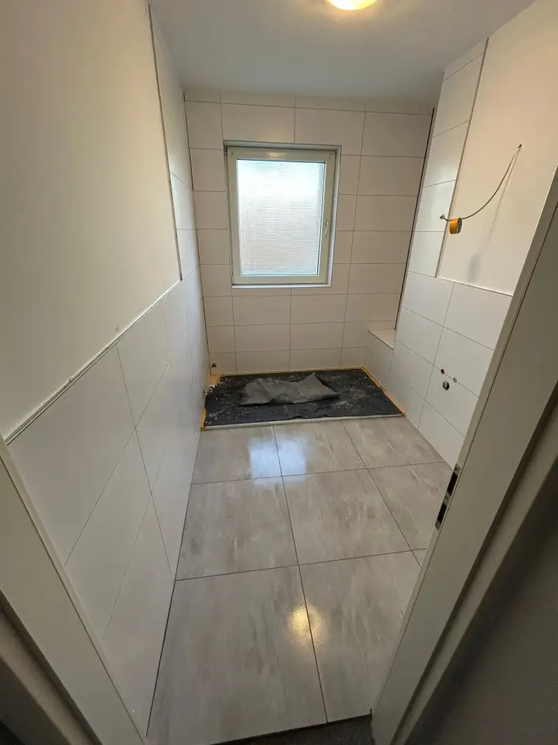 Badezimmer mit hellen großformatigen Wand- und Bodenfliesen