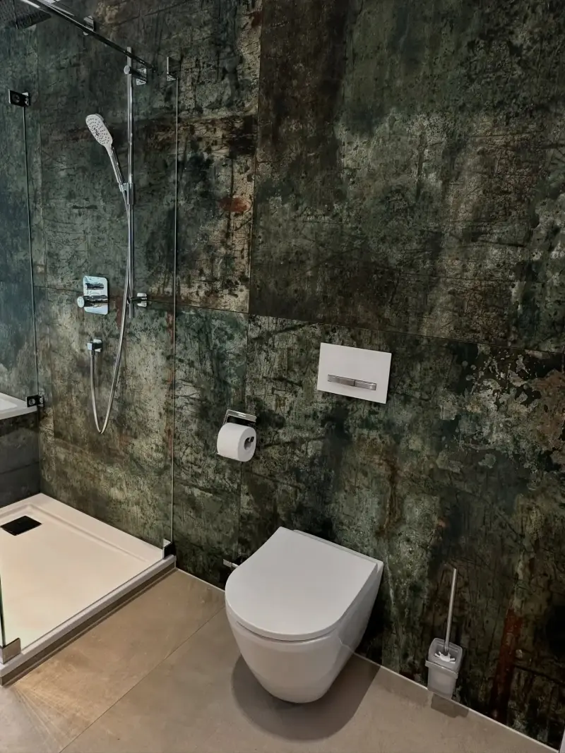 Walk-in-Dusche mit dunklen Fliesen in Natursteinoptik