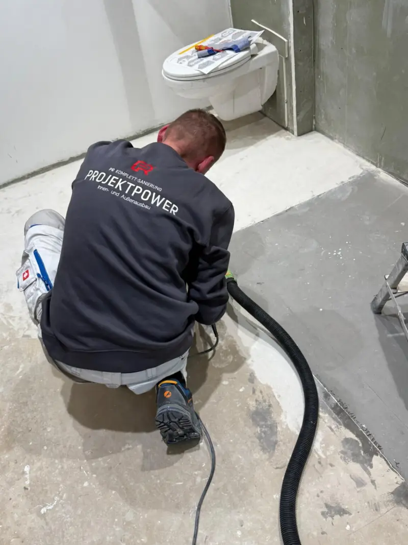 Handwerker bei Fliesenarbeiten während einer Badsanierung