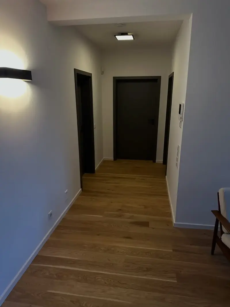 Sanierter Flur mit Holzboden, neuen Türen und Wandleuchten