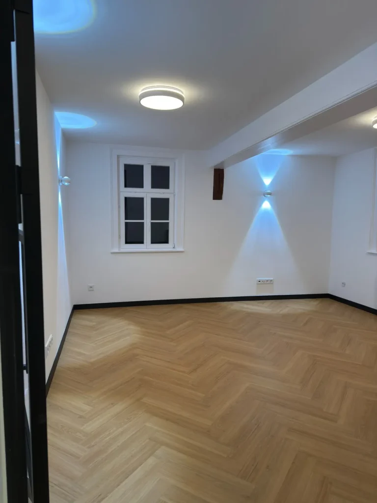 Moderner Innenausbau mit Fischgrätboden und indirekter Beleuchtung