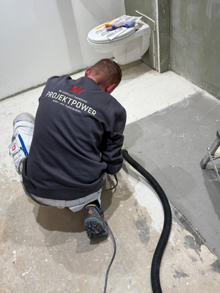 Handwerker bei Fliesenarbeiten während einer Badsanierung